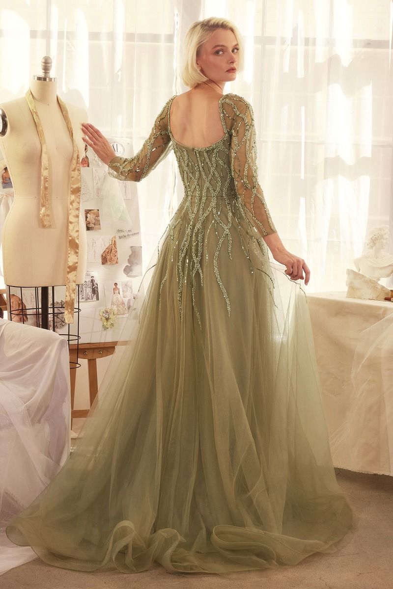 Impresionante vestido de corte A, con escote en forma de corazón, mangas largas y espalda semiabierta, falda de tul en capas brilla con una aplicación lineal de lentejuelas