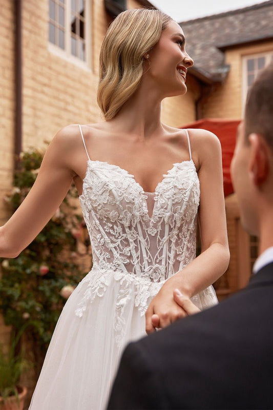 impresionante vestido de novia corte A de tul, corpiño de encaje con intrincadas aplicaciones está enmarcado por tirantes finos y espalda tipo corsé con cordones