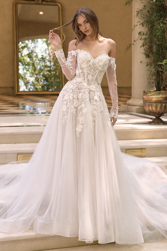 Vestido de novia presenta un escote de hombros descubiertos con mangas transparentes de efecto ilusión y un corpiño tipo corsé adornado con aplicaciones florales aplicadas a mano